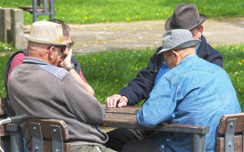 Group of men playing a board game outside.