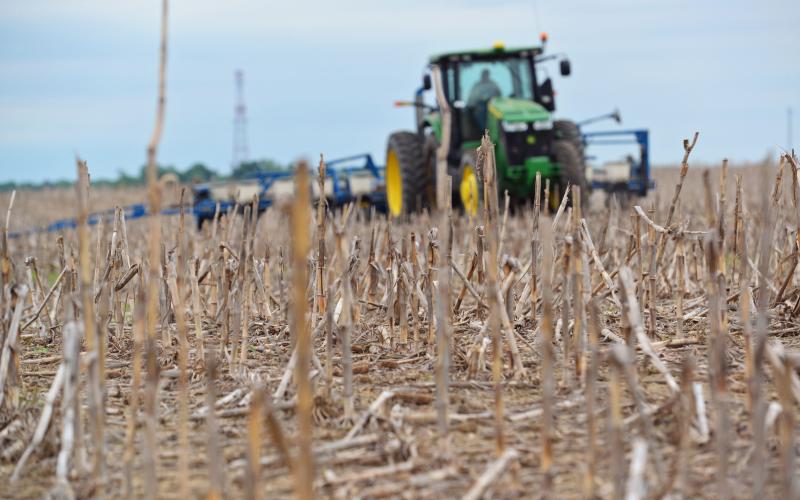 A green tractor planting seeds in a no-till field. Courtesy: United Soybean Board [CC BY 2.0] via Flickr