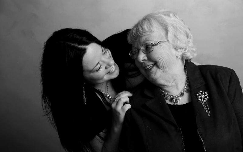 older mother and adult daughter smiling at each other