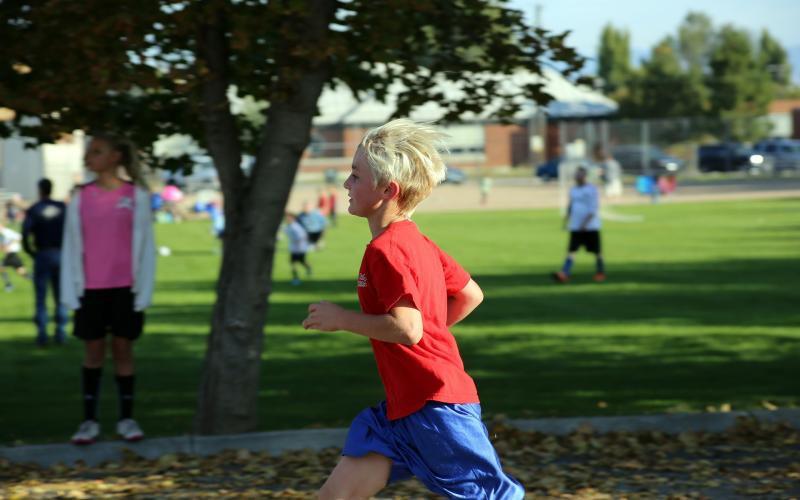 a young boy in a red shirt running