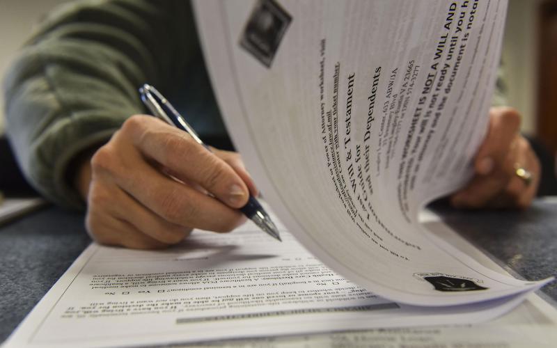 A man reviewing an information packet on creating a last will and testament.