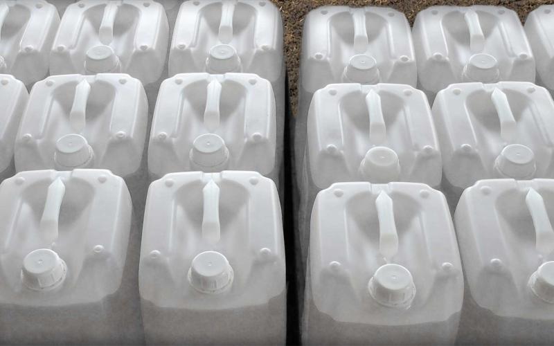 Rows of empty white, plastic pesticide containers.