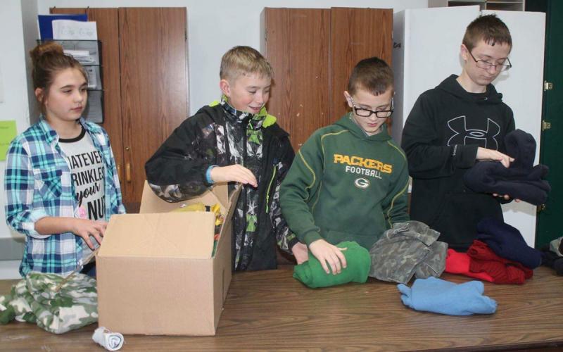 Ryan Sell and several other kids collecting warm clothes for donation.