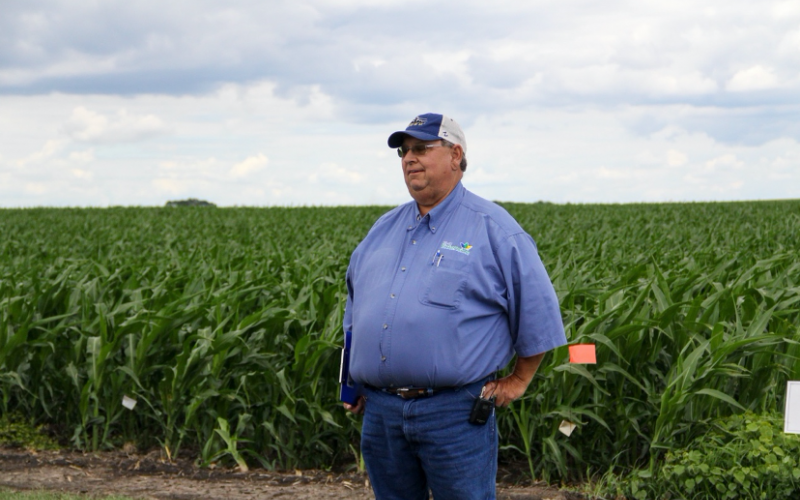 a man standing in front of a cornfield