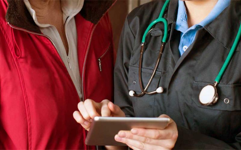 Veterinarian and rancher reviewing testing information on a tablet.