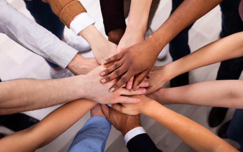 00-03-equity-teaser multiple people's hands stacked together