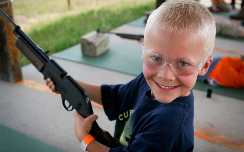Young boy holding a bb gun.