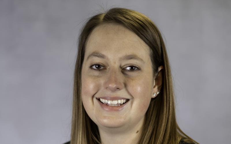 a woman wearing a maroon shirt and black jacket