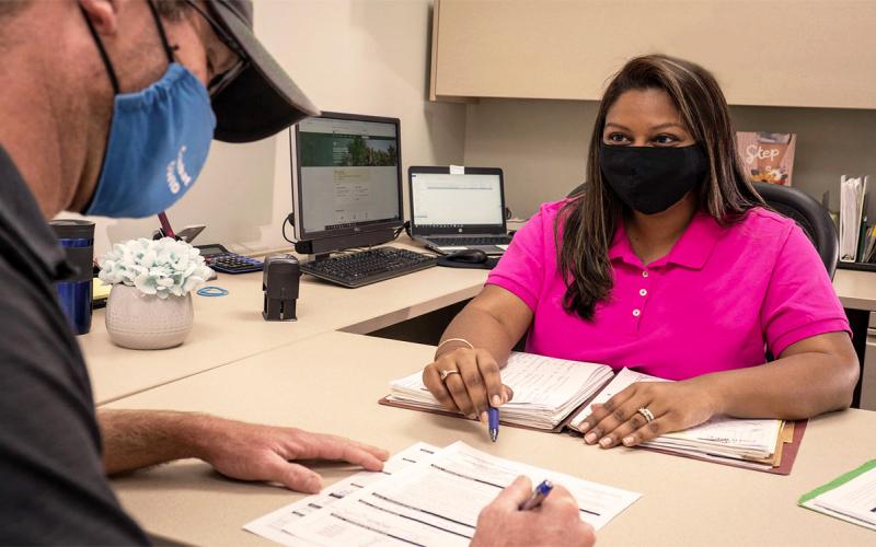 Producer and crop consultant reviewing paperwork at a desk.