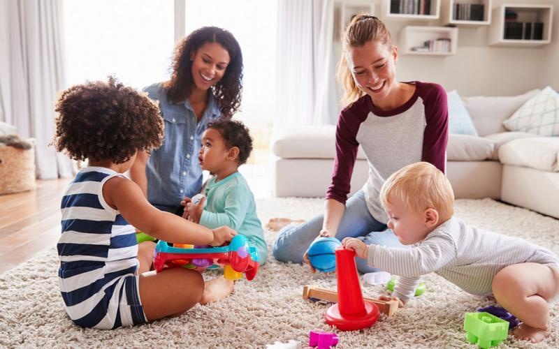 Parents playing with their children in a living room.