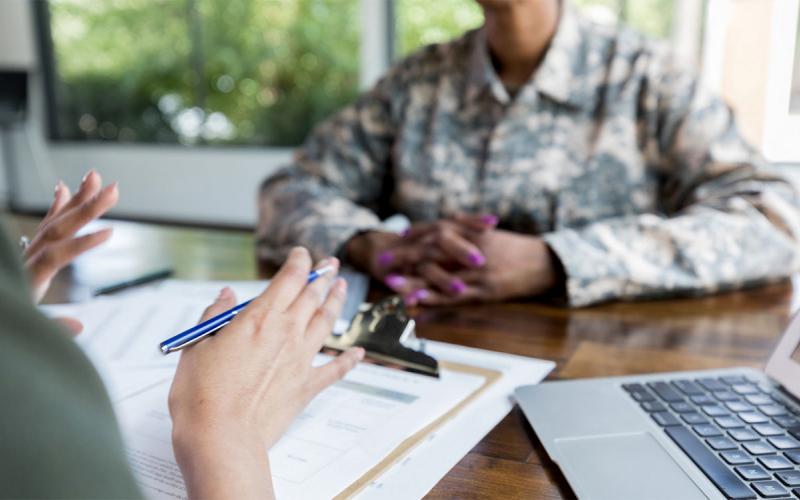 Instructor and female grant applicant reviewing paperwork at a table.