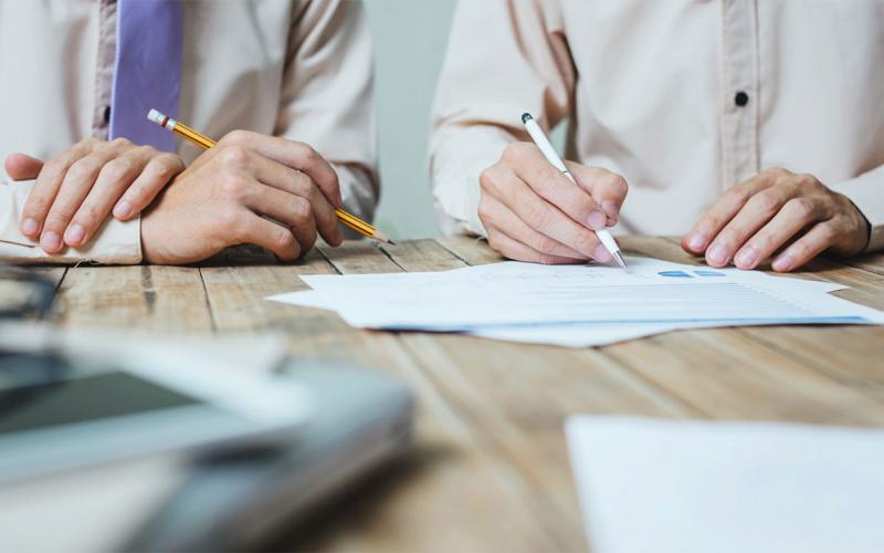 Two board members reviewing legal paperwork at a table.