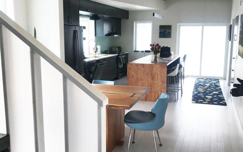 Modern, adaptable kitchen with ample space around essential features, including stairs and appliances.