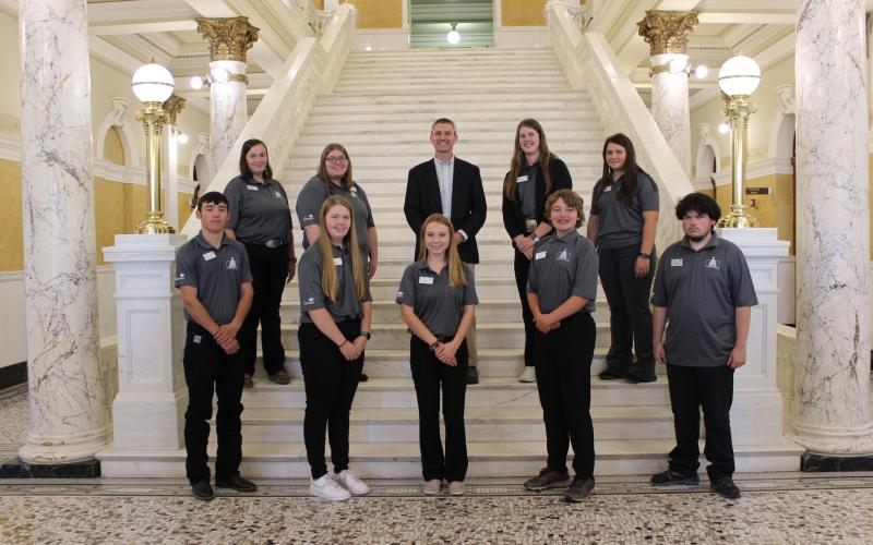 South Dakota 4-H Program Director Tim Tanner with a group of 4-H youth on the grand staircase inside the South Dakota State Capitol.
