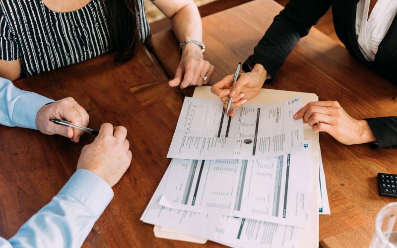 Financial advisor reviewing paperwork with a couple.