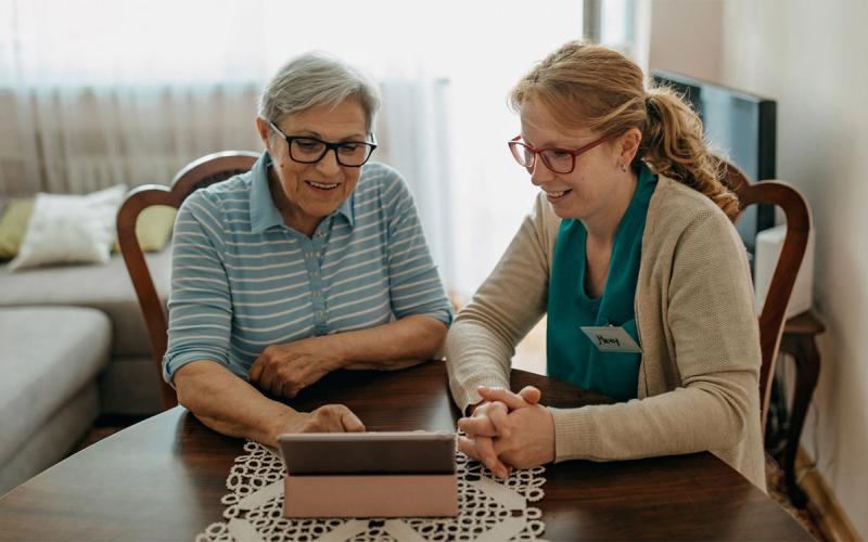 Home health care specialist visiting with an older female adult.