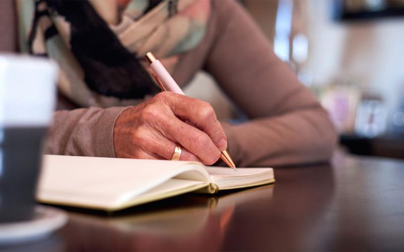 Woman writing in a journal.