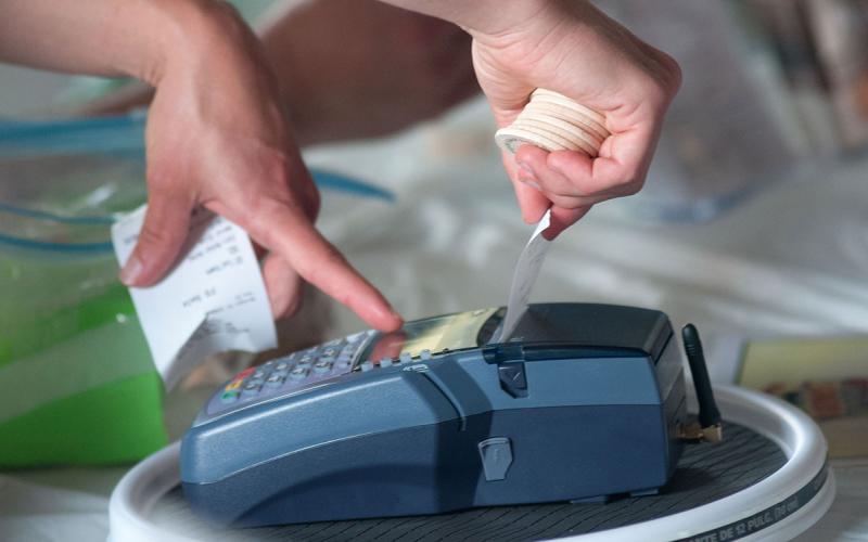 Wireless Point of Sale Device dispensing a sales receipt at a farmers market.