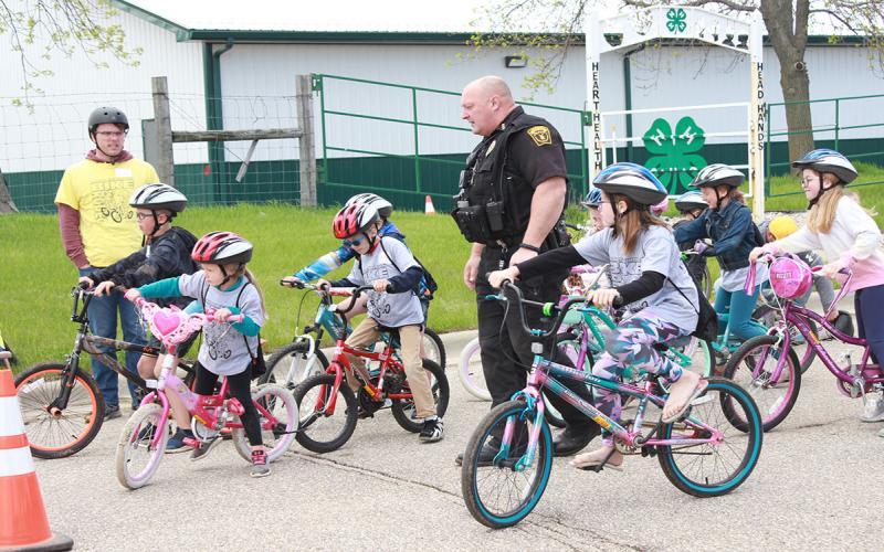Group of youth riding bikes through a bike handling station.