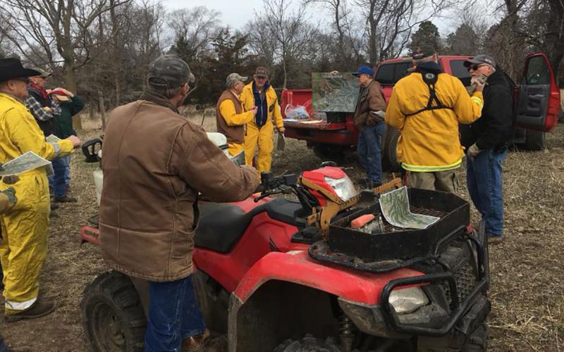 Tom Hausmann gives a briefing before the burn, while Greg Schmitz listens with the rest of the burn crew.