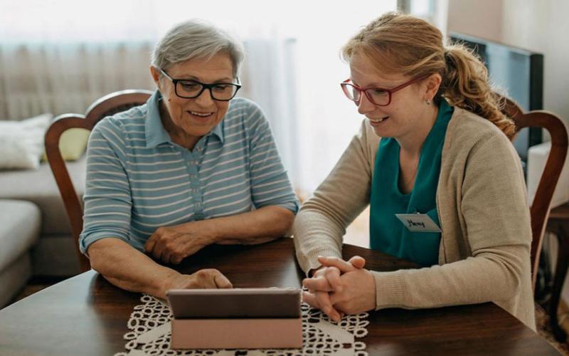 Home health care specialist visiting with an older female adult.