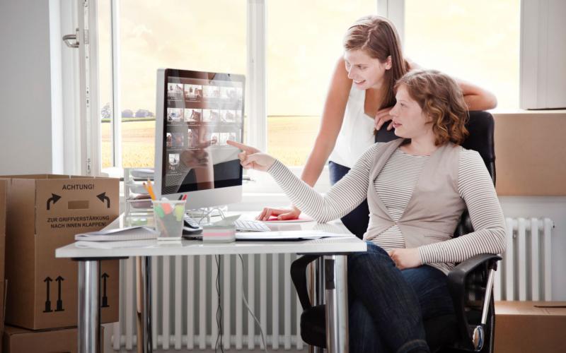 Two women setting up a remote workstation.