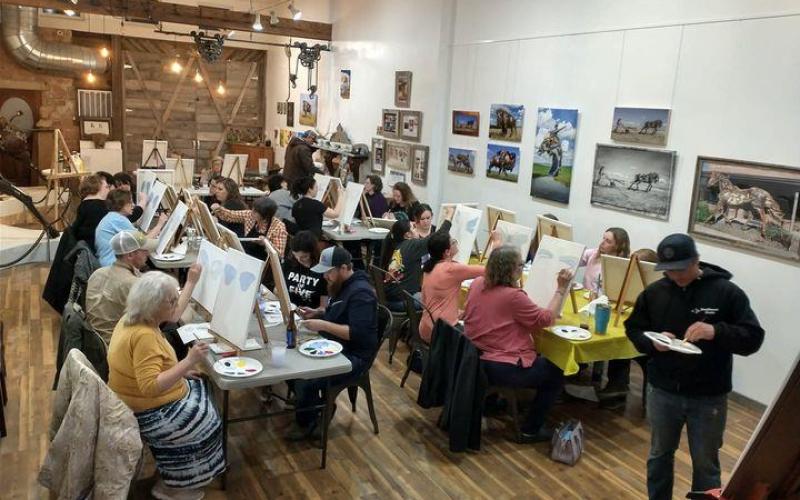 A picture of around a dozen local artists in Lemmon, South Dakota, posed in front of easels.