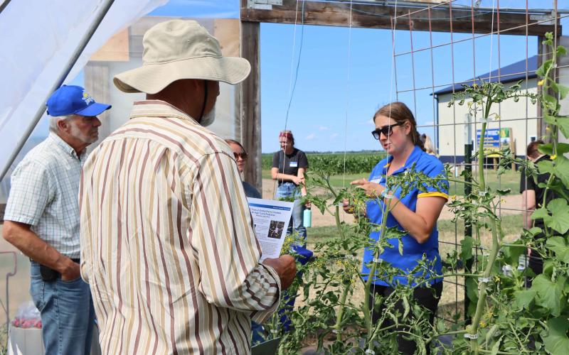 An Extension specialist speaks to two attendees at the 2022 Research Farm Field Day