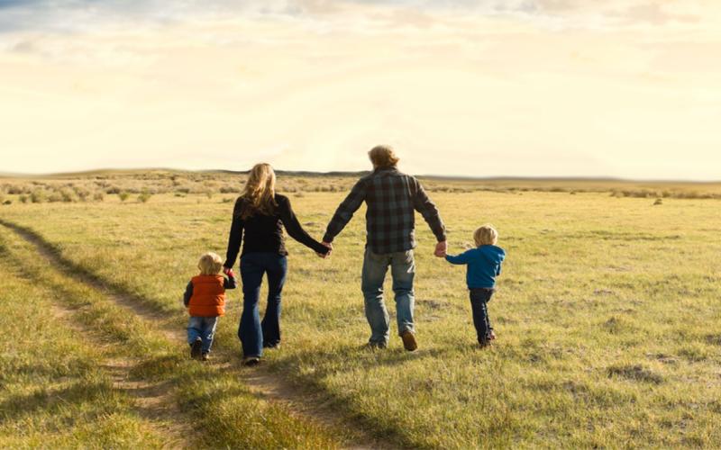 Family walking in an open, country field.