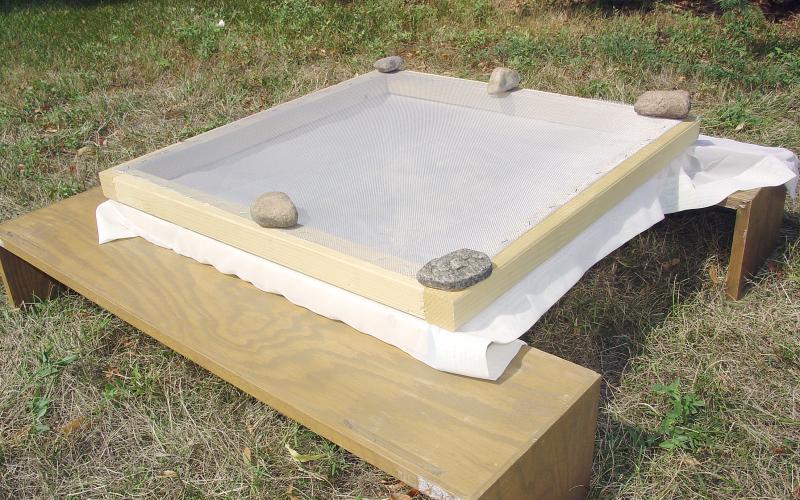 Sun-drying screens with a white sheet in the middle