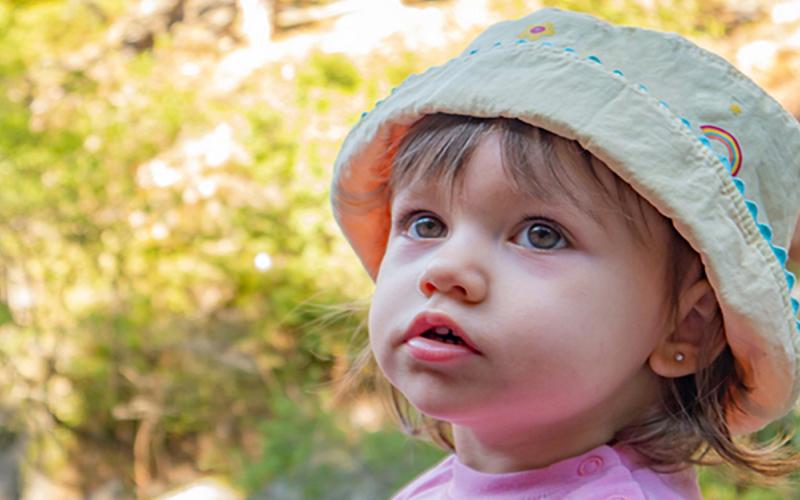 Child wearing a sunhat.