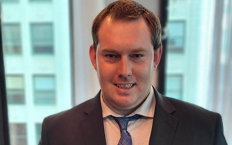 a man in a suit and tie smiles for the camera
