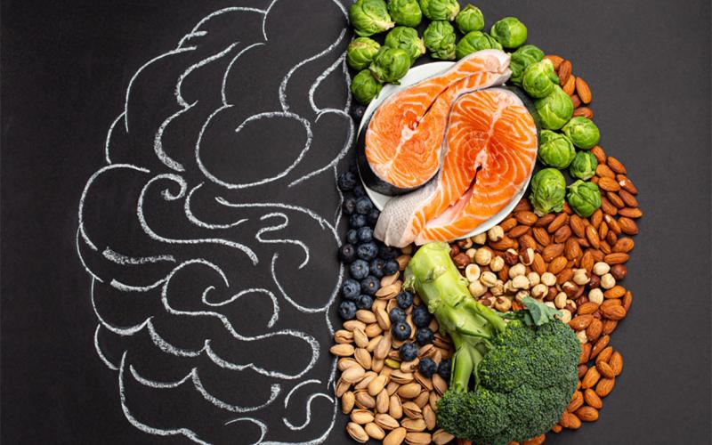 Variety of healthy foods laying over a chalk illustration of a human brain.