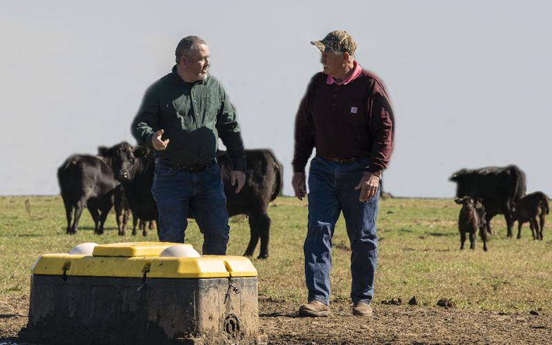 Two producers observing an in-field cattle watering unit.