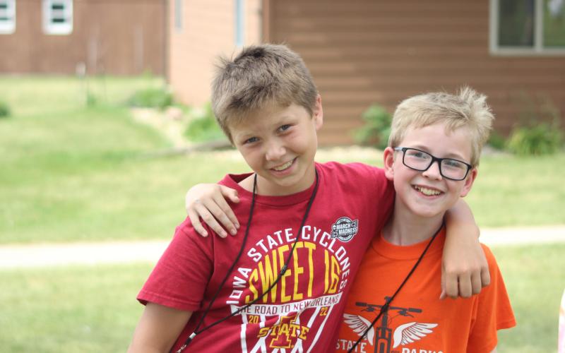 Two youth with their arm around each other at camp