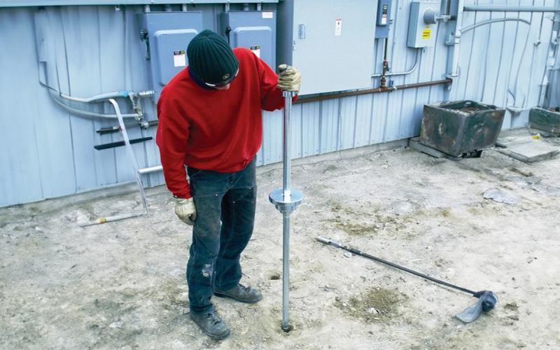 Man using a dynamic cone penetrometer.