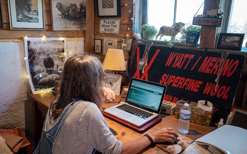 Sheep producer viewing information on a laptop computer.