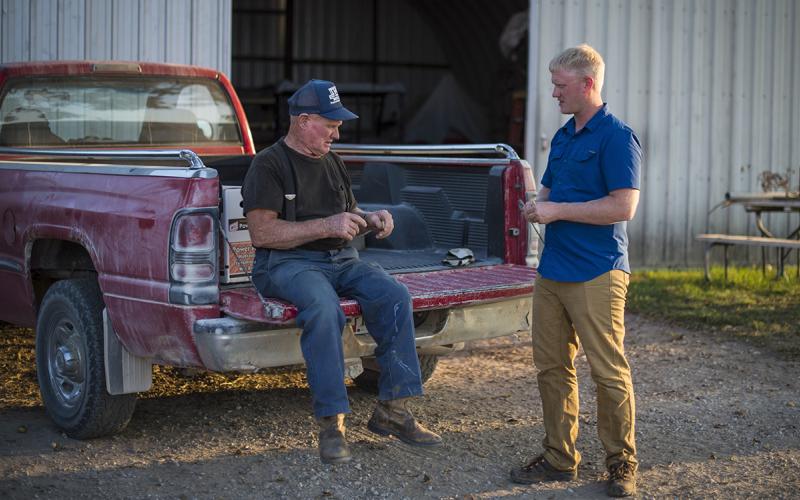 An older producer and his grandson having a discussion on their family farm.