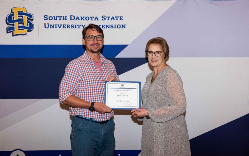 Chris Graham receives a certificate from Karla Trautman