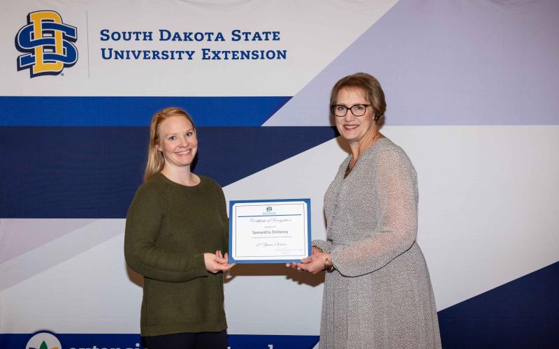 Samantha DeVaney receives a certificate for 10 years of service from Karla Trautman