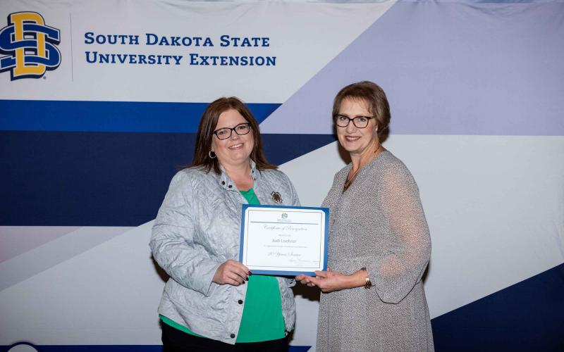 Jodi Loehrer receives a certificate for 20 years of service from Karla Trautman