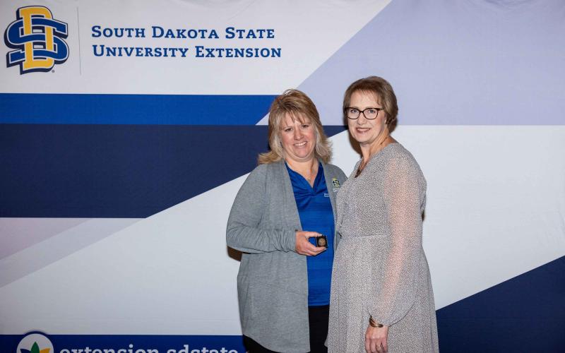 Deanna Gall receives a pin for 25 years of service from Karla Trautman