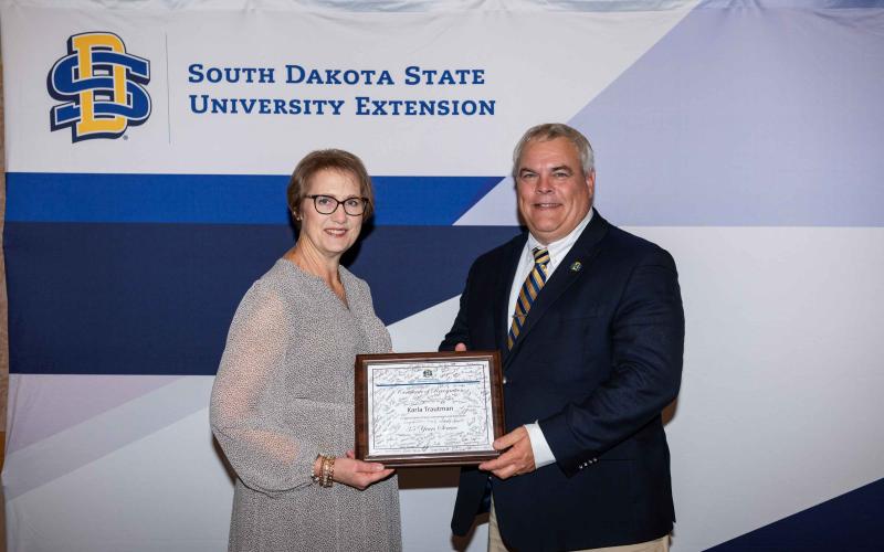 SDSU Extension Director Karla Trautman receives a certificate recognizing her 35 years with SDSU Extension from Joseph Cassady, South Dakota Corn Endowed Dean of the College of Agriculture, Food and Environmental Sciences at SDSU