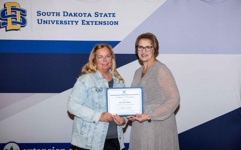 Lori Oster receives a certificate for 5 years of service from Karla Trautman