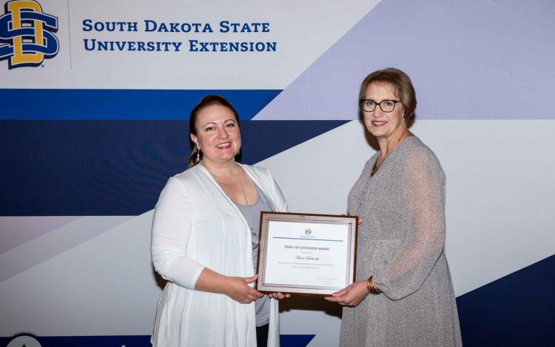 Aimee Ladonski smiles and receives her certificate from Karla Trautman