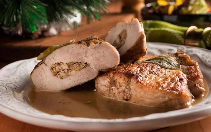 Stuffed porkchop with gravy on a holiday table setting.