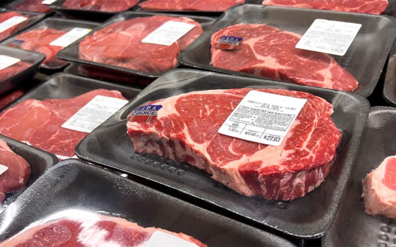 USDA Choice ribeye steaks on display at a grocery store.