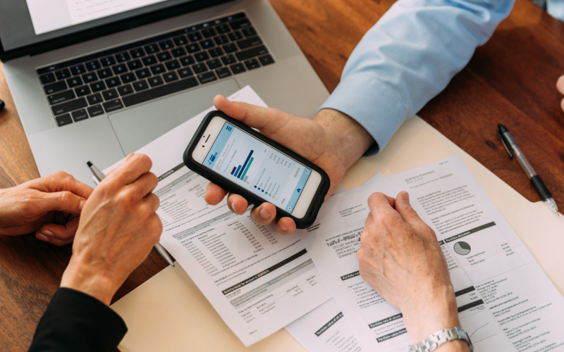Three people looking at financial documents