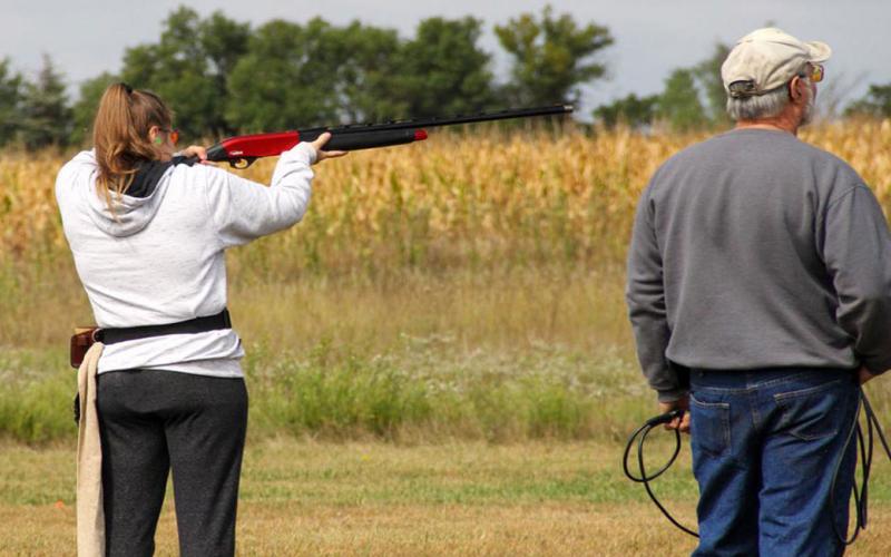 4-H shooting sports coach and youth at a trap shooting range.