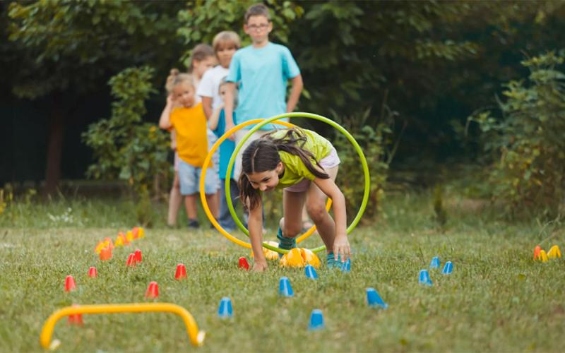 Group of kids racing through an obstacle course in their backyard.